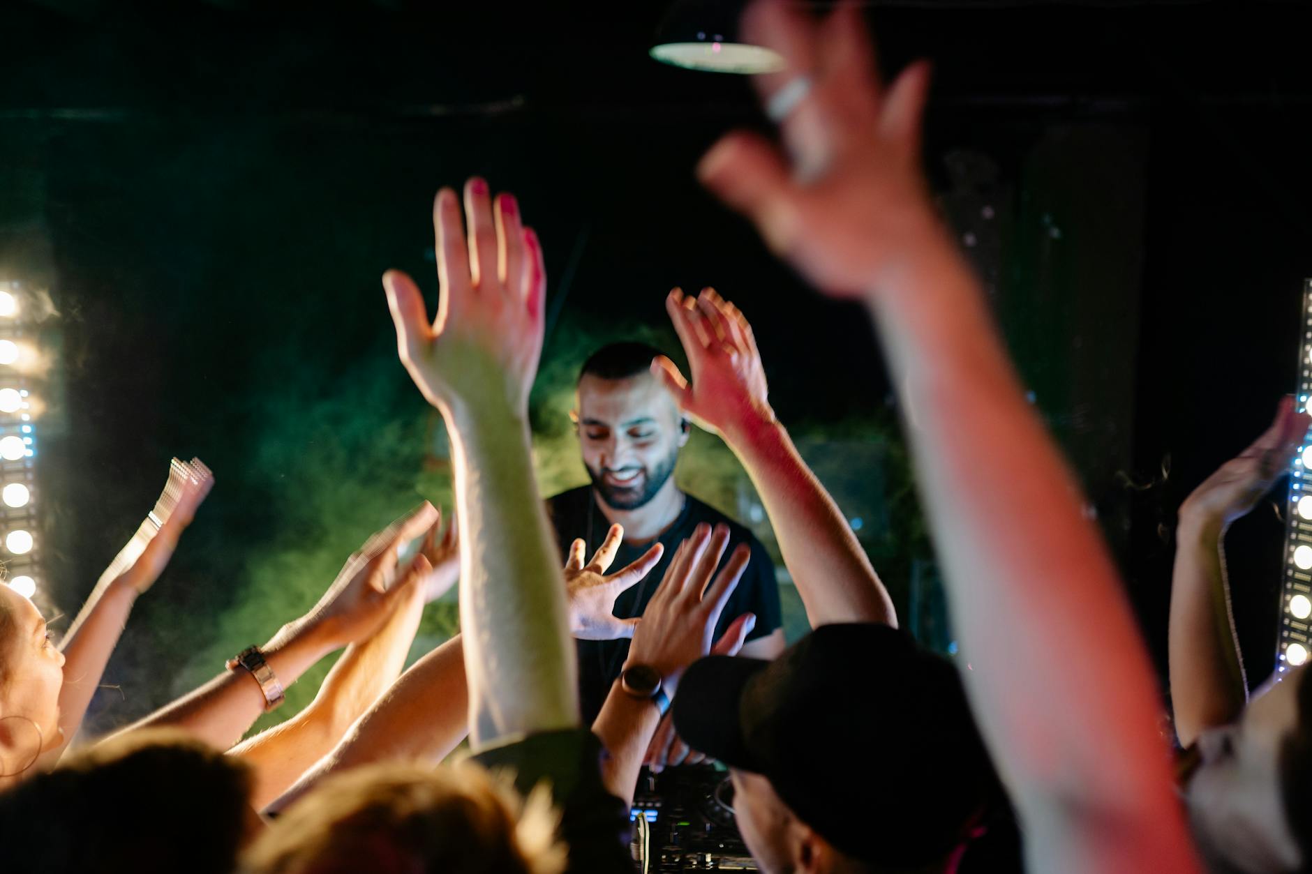 DJ at peak time mixing banger music in a packed nightclub